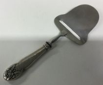 A Continental silver cheese slice in the Georg Jensen style.
