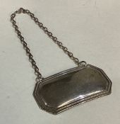 A silver engraved bottle label.