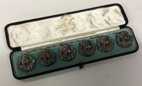 A set of six pierced Victorian silver figural buttons contained within fitted box.