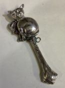 A silver rattle cast with a cat.
