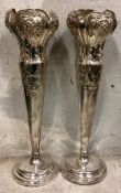 A large and oversized pair of embossed silver vases.