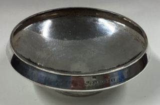 A silver bowl with hammered decoration.