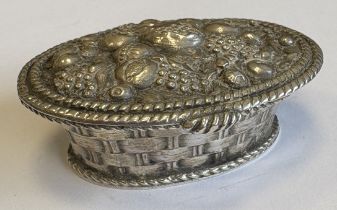 A chased silver pill box in the form of a basket of fruit.