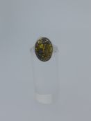 Silver ring set with natural green amber