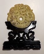 A White Jade Intricately Carved Chinese Amulet On A Custom Wooden Base
