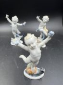 Three porcelain figures of dancing cherubs