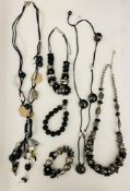 A collection of beaded long necklaces, onyx style black bracelet and other styles