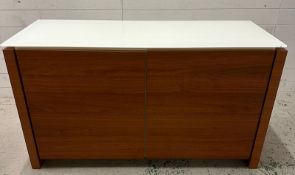 A contemporary white glass topped sideboard with two doors opening to glass shelving by Caligaris
