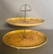 A vintage Japanese two tiered cake stand, yellow grounds and with a scrolling floral decorative