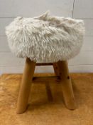 A faux sheepskin accent stool