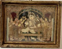 An Indian painted and relief panel depicting Krishna surrounded by attendants under an ornate