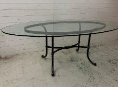 A wrought iron framed glass topped table (220cm x 120cm x 77cm)