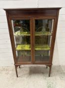 An Art Nouveau style display cabinet with two green crushed velvet shelves and two stained glass