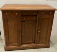 A side cabinet with four short drawers flanked by two long cupboards and one central cupboard (