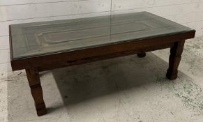 A mahogany glass topped coffee table, the wooden top upcycled from a cupboard door (H48cm W133cm