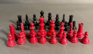 A set of lead chess pieces in red and black