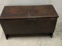 An oak coffer, single plank top opening to reveal interior with a candle box and raised feet (