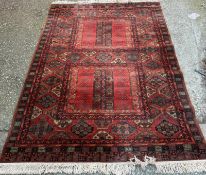A wool rug, red grounds with a geometric boarder 260cm x 170cm