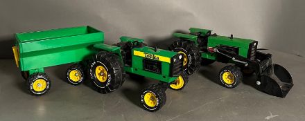Two vintage Tonka toy tractors, one with a trailer