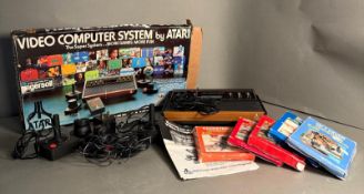 An Atari Video Computer System with games, manual, controllers etc.