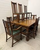 An oak extendable dining table on carved acanthus supports with a harlequin set of ten faux green