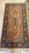 A wool runner, brown grounds with central medallion and geometric boarder 180cm x 90cm