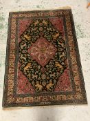 A Persian rug with central medallion with lions and floral design, signed to one end 170cm x 122cm