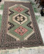 A green ground rug with diamond design to centre 250cm x 160cm