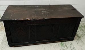 An English oak coffer with decorative carved panels (H67cm W150cm D54cm)