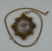 A Georgian gold-coloured metal 'Lovers Eye' painted pendant, oval with eye painting, on ivory,on a