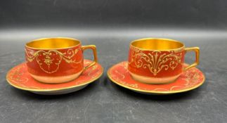 A pair of Dresden gilded tea cups with raised gilded decoration.