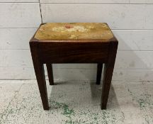 A dark oak stool, upholstered in a floral pattern