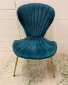 A contemporary single teal velvet dining chair on brass effect legs