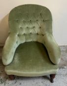 A green button back lounge chair on turned legs