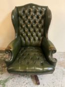 A green leather Chesterfield swivel desk chair with button-tufted upholstery