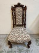 A Jacobean style hall chair with barley twist supports on carved cabriole legs and castors
