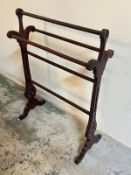 A mahogany towel rail with scrolling ends