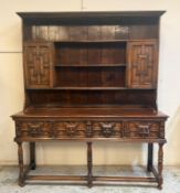 A Jacobean revival oak dresser, plate rack top with two small cupboards, the base having two deep