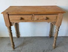 A pine side table on turned legs and drawers to centre (H76cm W90cm D40cm)