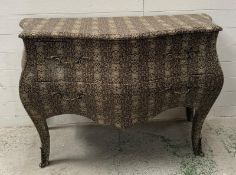 A bombe fronted two-drawer chest with a snakeskin effect finish and ornate ormolu mountings (