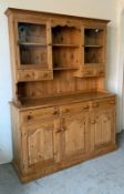 A pine Welsh dresser, the base with three drawers over three cupboards, the top with two glazed