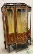 A French serpentine-fronted display cabinet in kingwood and walnut, with marquetry-inlaid bombe