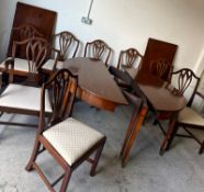 A mahogany dining table with string inlay and tapering legs with eight chairs