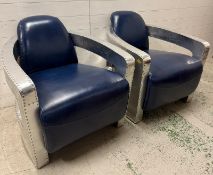A pair of blue aviator chairs, with riveted aluminium panels and padded leather upholstery