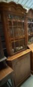 A veneered astragal glazed free standing corner cabinet with cupboard under (H190cm W69cm D42cm)