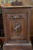 A heavily carved oak coal bin with galleried top