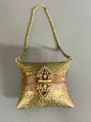 A brass decorative cushion themed purse with blue velvet lining and copper banded decoration and