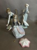 A selection of three Lladro figures: Lady feeding a swan, Lady picking flowers, Lady with parasol.