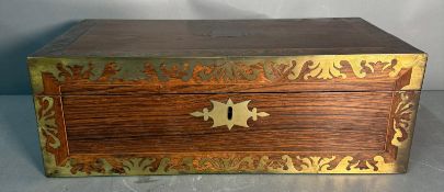 A mahogany writing slope with intricate brass inlay and central escutcheon inscribed 