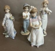 A selection of four Lladro figures of children in various poses.